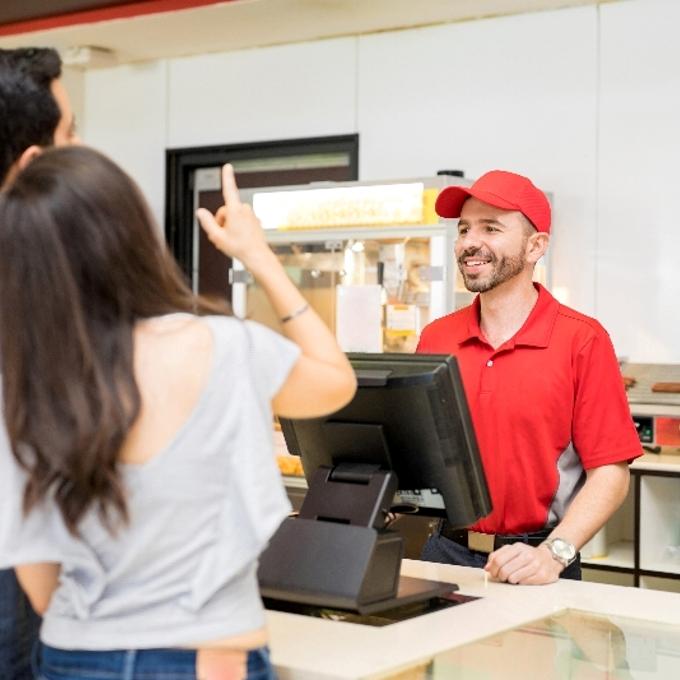Customers being served at a fast food QSR counter.